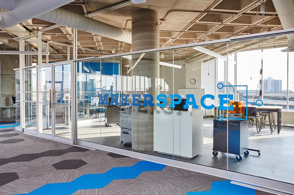 A wall of glass divides the Makerspace area from the rest of the library floor with a decal that indicates its name.