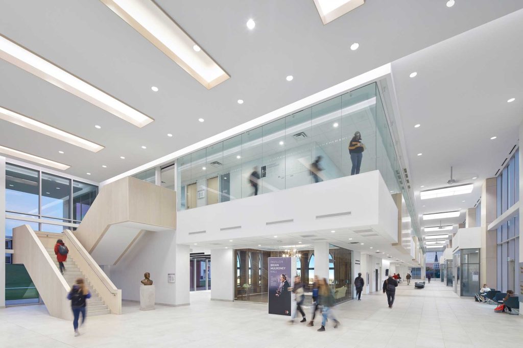 Students move through the Mulroney Institute with a birch wood stair and glass lined second floor which overlooks the main floor.