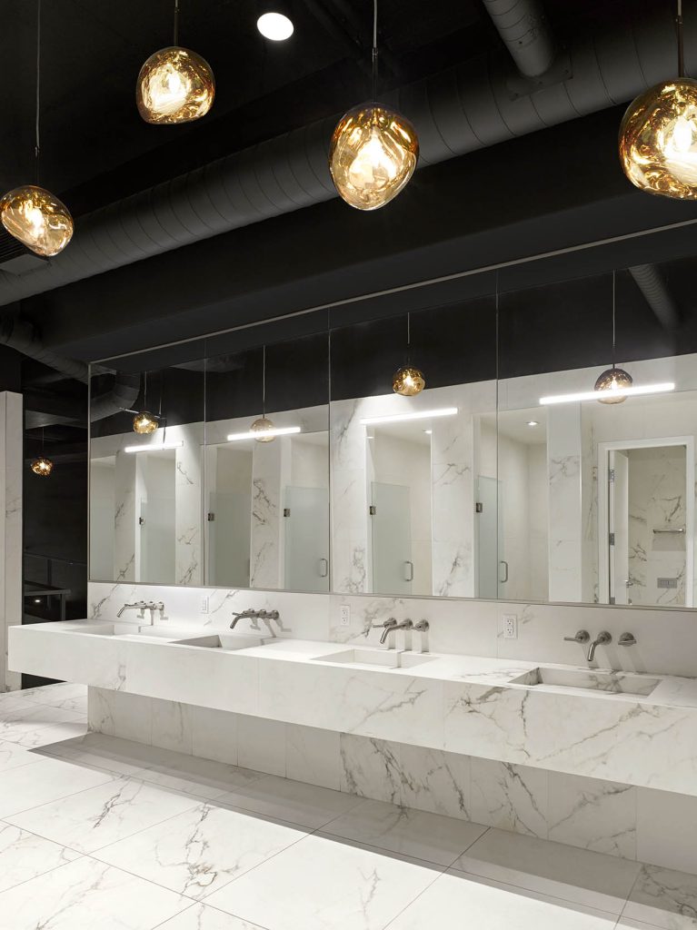 Changeroom sinks with marble all over, ceiling height mirrors and beautiful accent pendants above