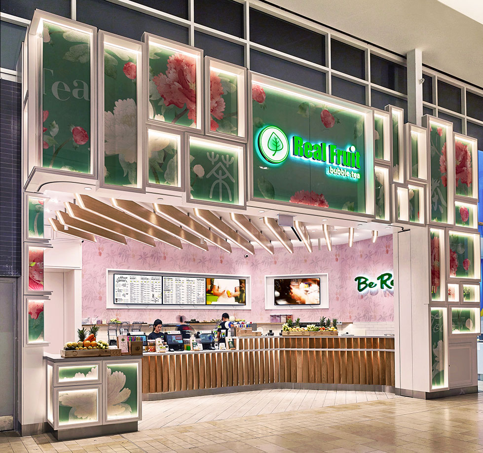 Individually lit white boxes with Asian Inspired graphics make up the storefront design. The wooden planks floating overhead in the interior subtly directing customer flow.