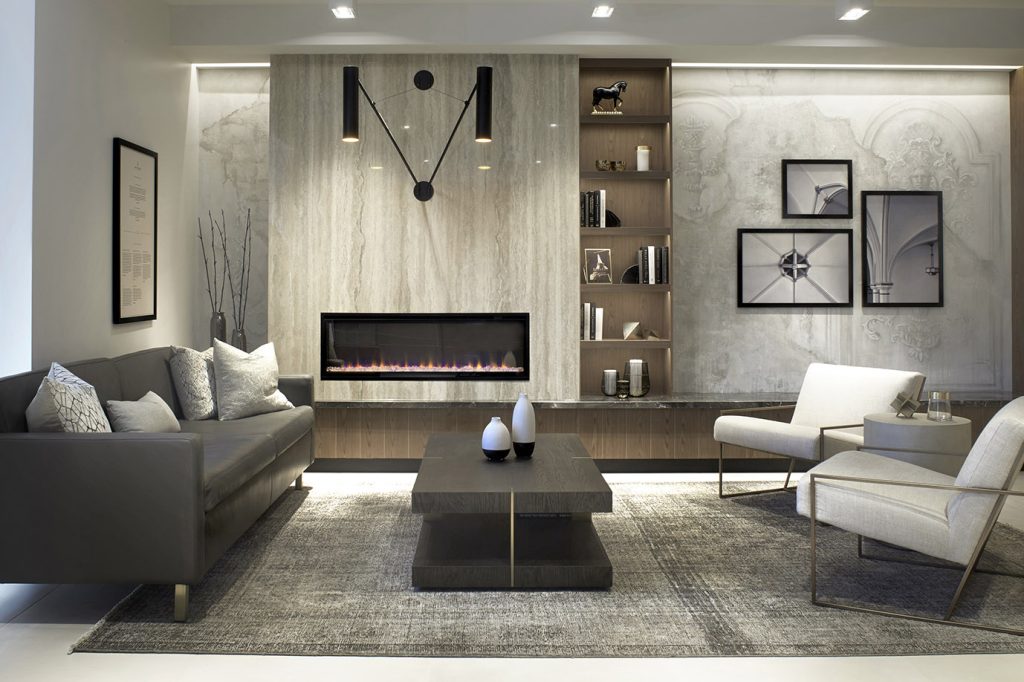 A living room setting with luxurious finishes and built-ins on the walls and modern high end furniture, all in welcoming beige and white neutral palette