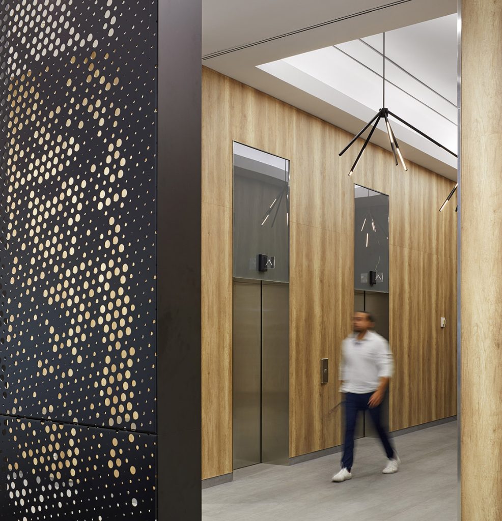 Elevator lobby with wood paneling and modern linear light fixtures in black finish
