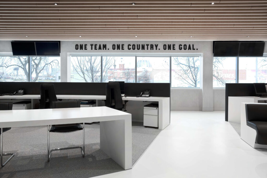Views of the Toronto skyline through a wall of windows in this open concept work space in a black and white color scheme.