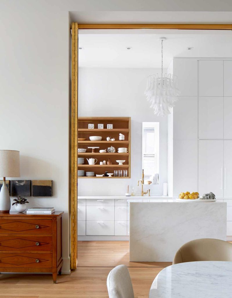 The brass screen is almost entirely open allowing a peek into the kitchen from the dining area
