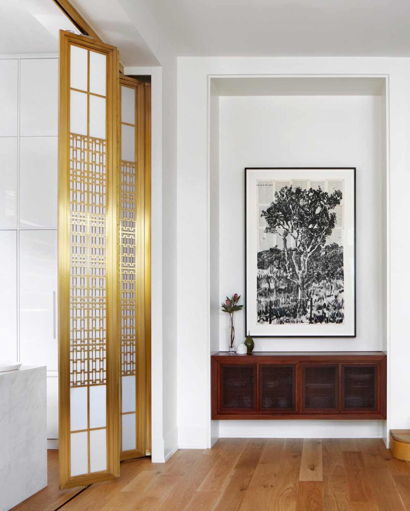 A console unit beside the new 1930's inspired brass screen dividing the kitchen from this dining area