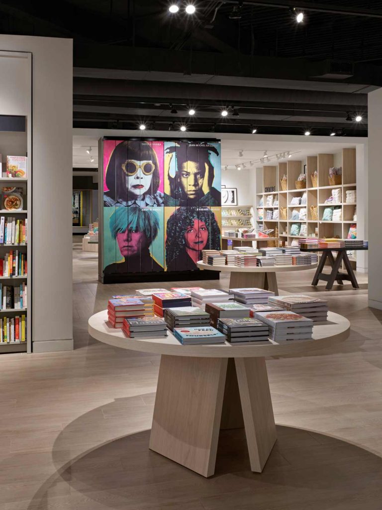 Beautiful round tables displaying books, spread out throughout the store interior allowing circulation through the interior to explore every bit