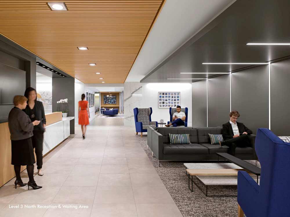 A long bright reception area with a new desk in marble and wood finish and a lounge/waiting area on the opposite side leading to the office interior