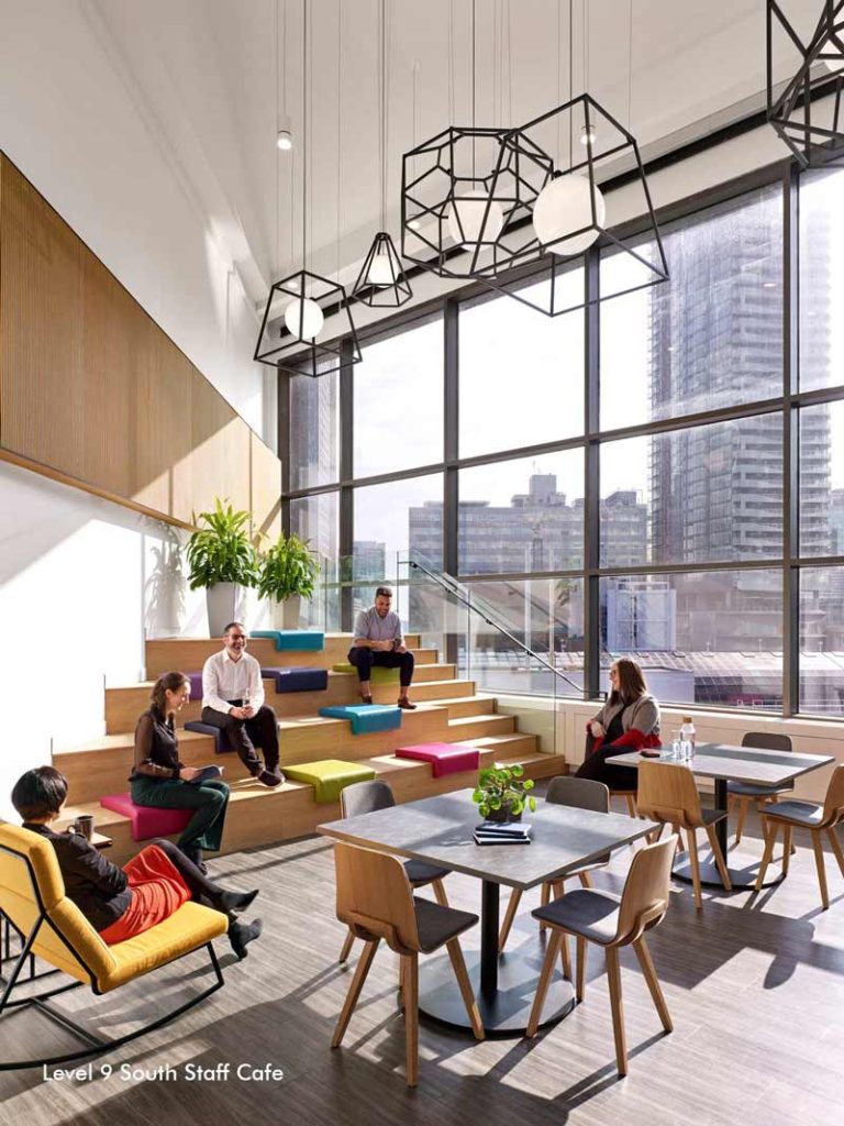 Staff cafe and common area with tables and wooden step seating, perfect for break time and collaborating