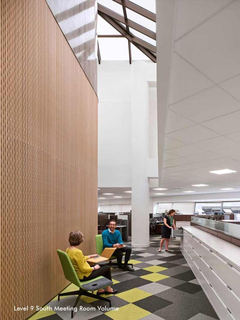 South meeting room volume showing the skylight a wood finish on the wall, neutral decor and furniture with some yellow accents on the carpeting.