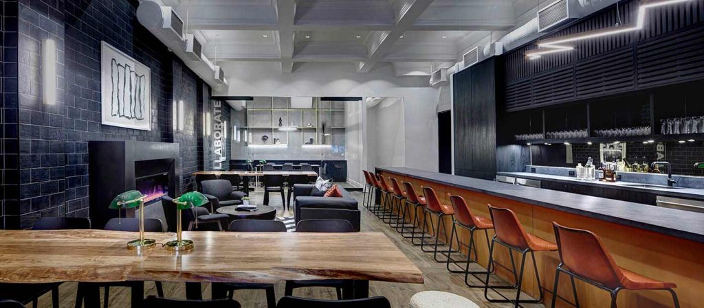 Large bar in on the right running along the entire depth of the room and lounge spaces on the left for comfortable seating and collaborating. Predominantly black and wood finishes