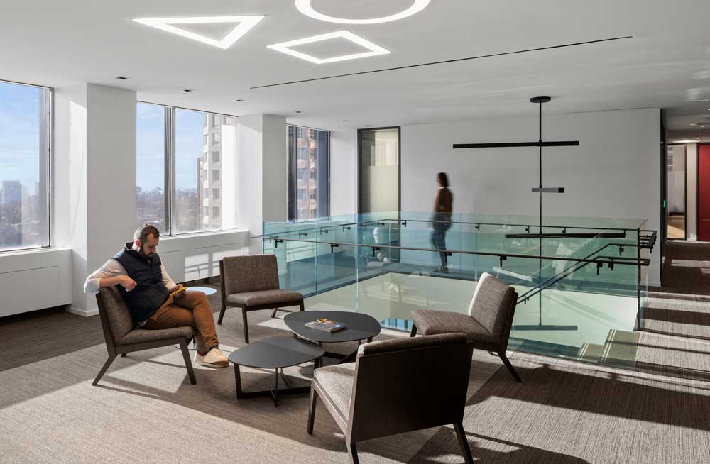 second level lounge area is placed right next to the glass encased staircase