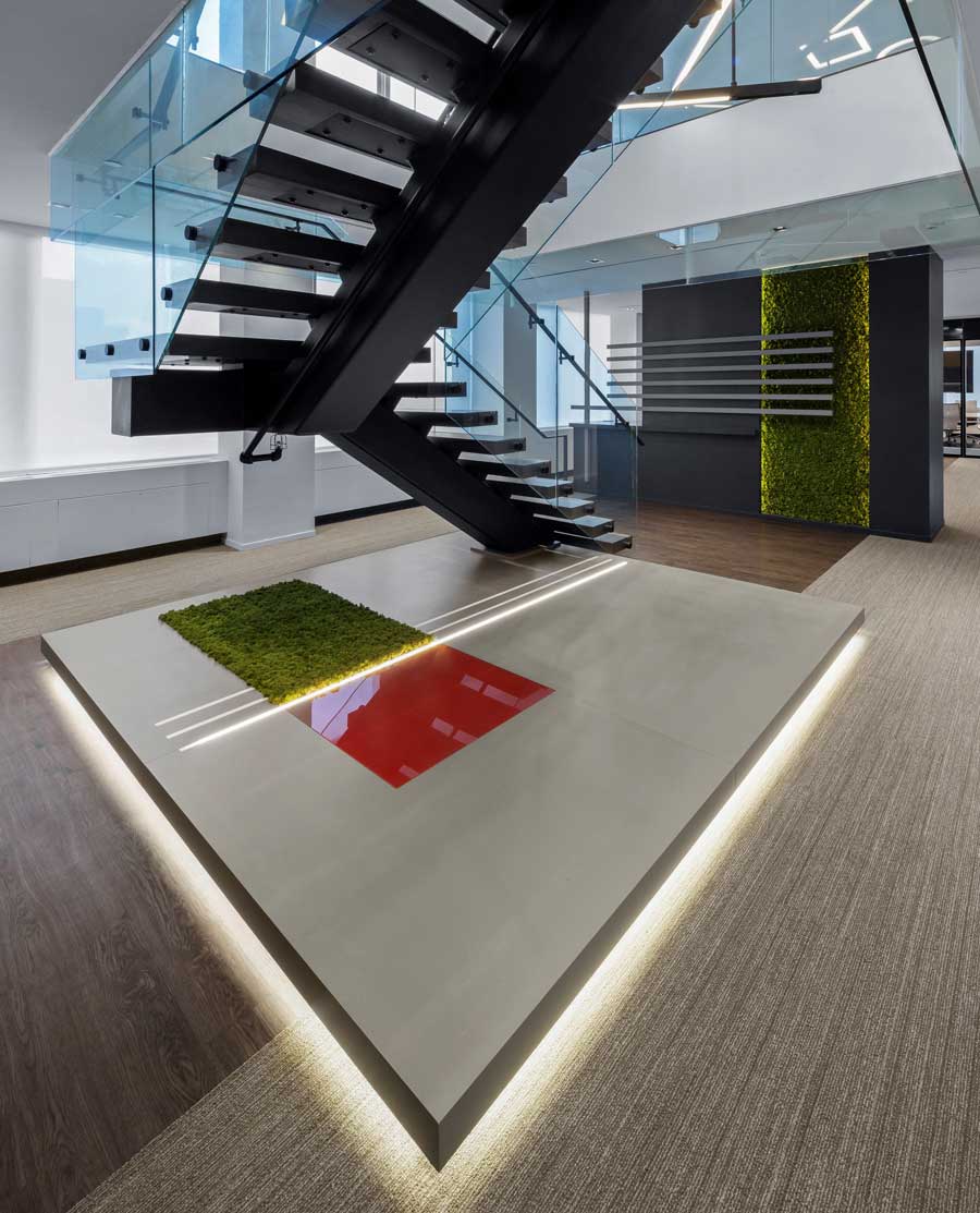 Another view of the bottom of the staircase on the lower level, with geometric details on the floor and biophilic detailing on the walls