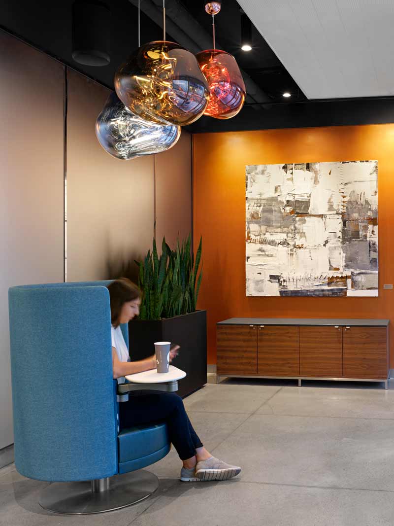 Lounge area with club chairs anchored by large organic globes as pendants