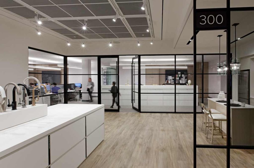 At the other end of the showroom are the design studio and offices behind a large glass wall separating the showroom from the office area