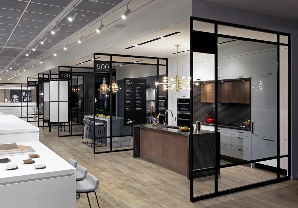 One side of showroom environment showcasing sample kitchens separated with glass walls