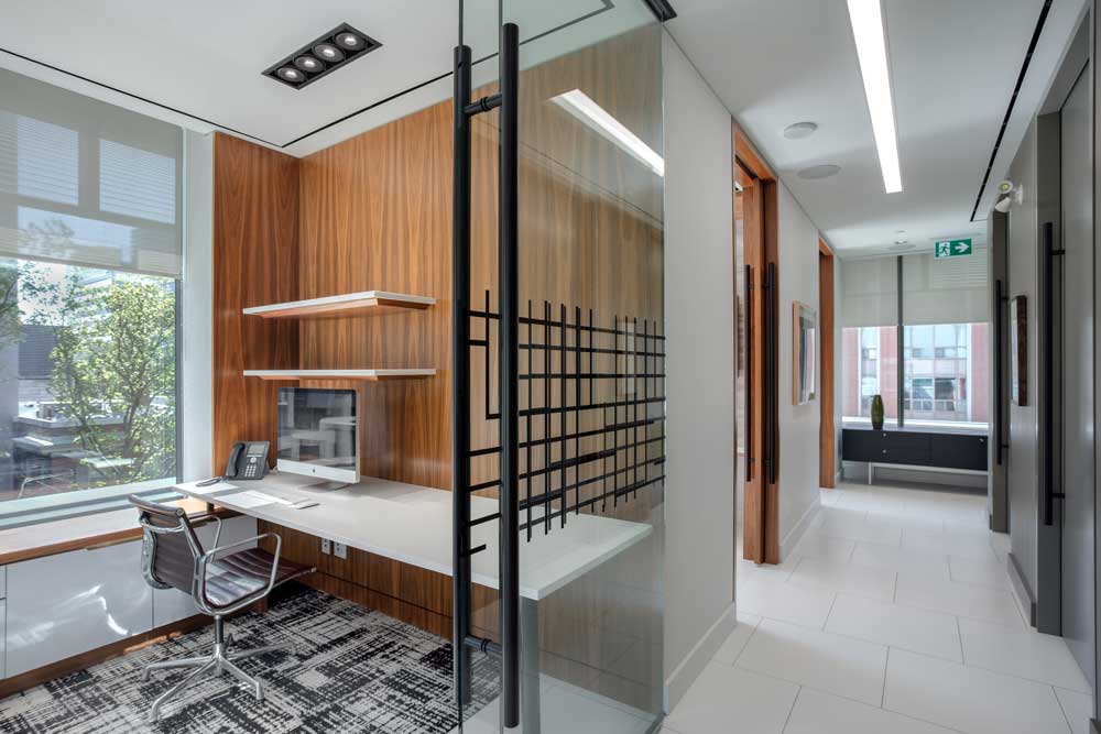 A peek into one of the consultation offices through the glass doors with black geometric patters printed on them