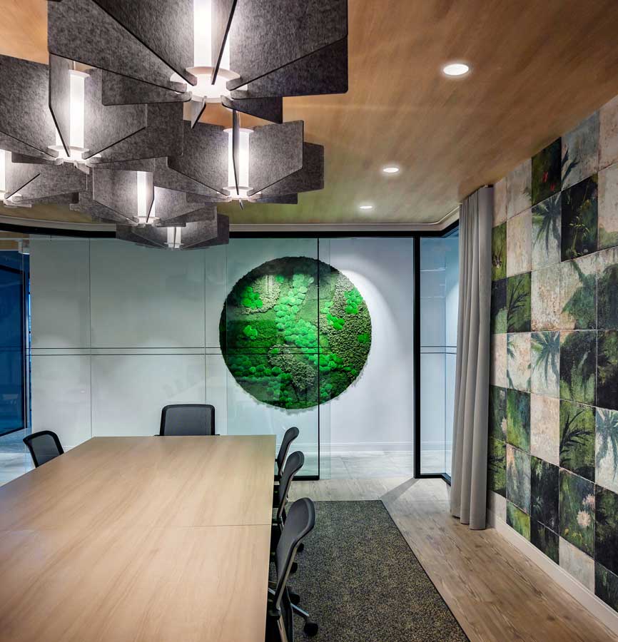 A view from inside the meeting room with the circular biophilic design visible on the opposite wall of the hallway through the glass wall