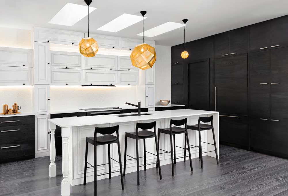 Black and white kitchen in a mix of contemporary and traditional styles and gold accents in a form of hanging pendant lights
