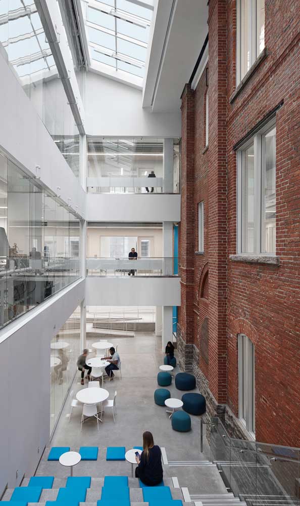 Contrast between the old brick building on the left and the new addition on the right. The common area atrium in the middle