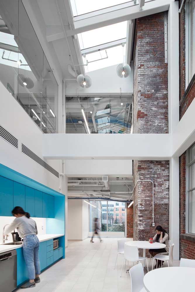 Lounge and kitchen area in between the two contrasting buildings, between old and new with brick exposed