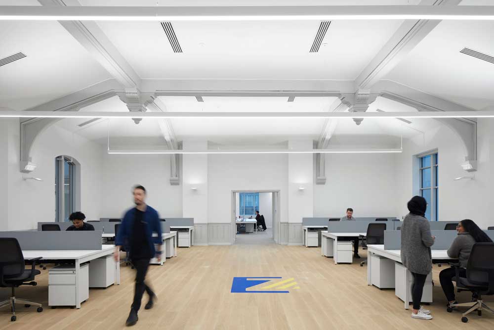 A spacious and bright study area with traditional ceiling details mixed with contemporary lighting