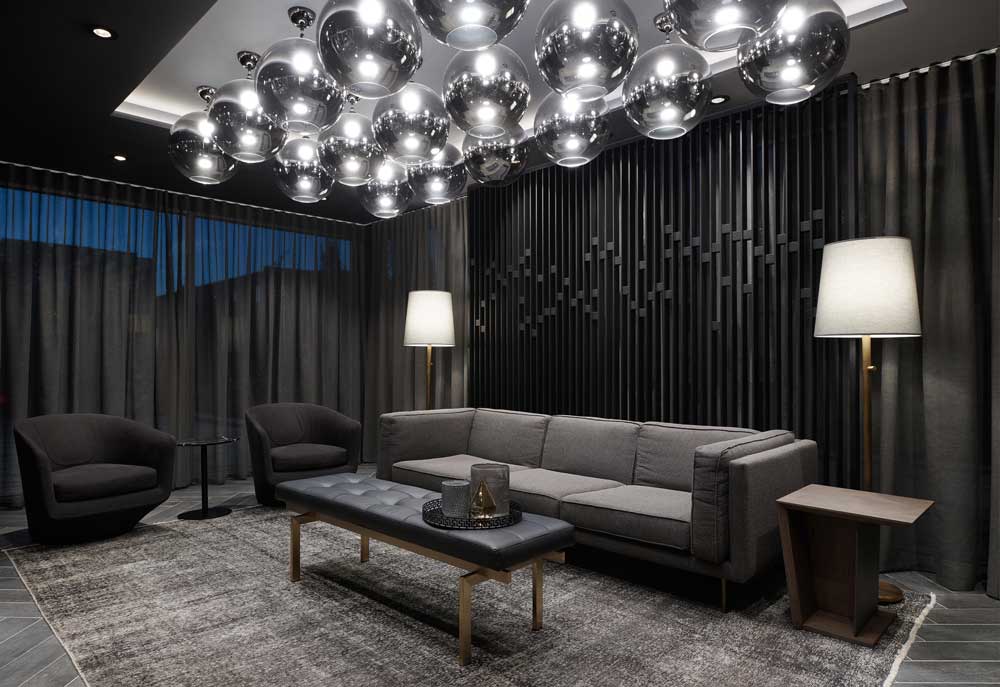 Sofa in the lounge area designed in a neutral colour scheme with luxurious interior finishes and materials