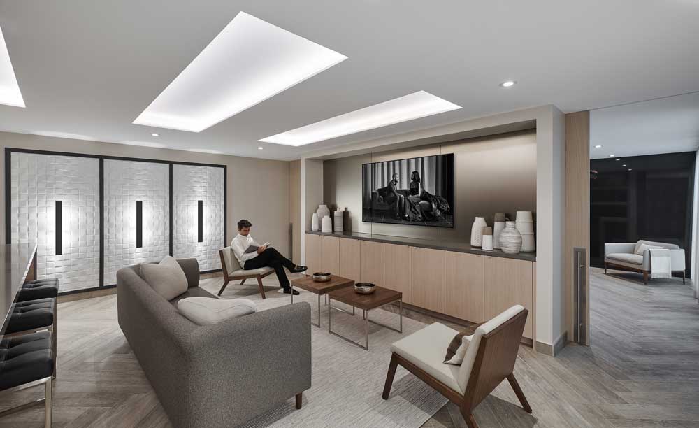 A bright living room setting with built in wall cabinets and neutral mid century furniture