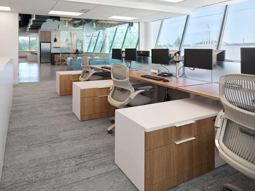 Open concept work station area adjacent to the kitchen, with views through wall of windows