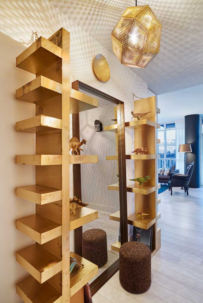 Brass shelving at the front entrance to display dinosaur collection and a large mirror in between