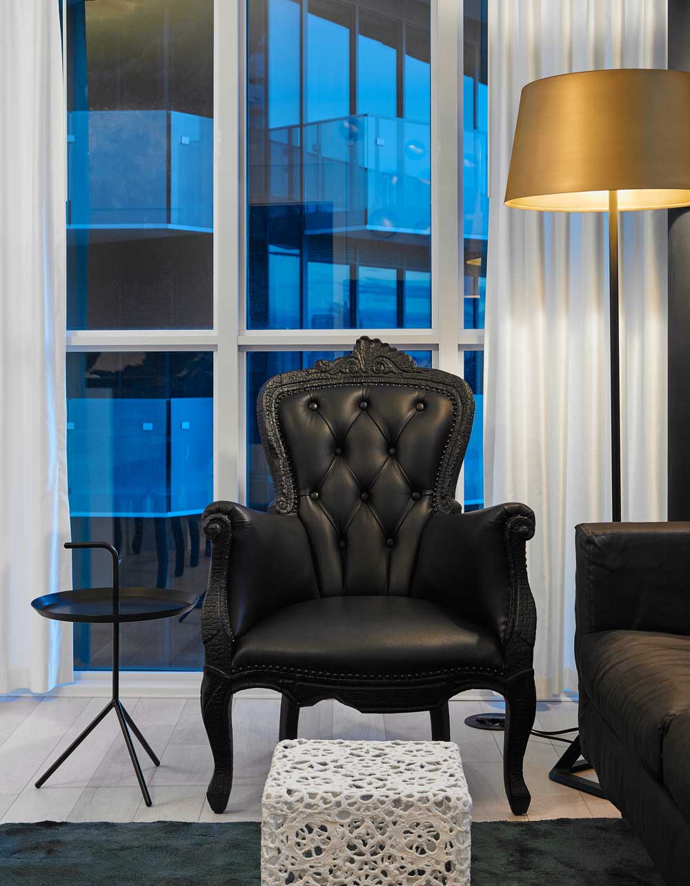 Detail of a lounge chair in black leather in modern glam style