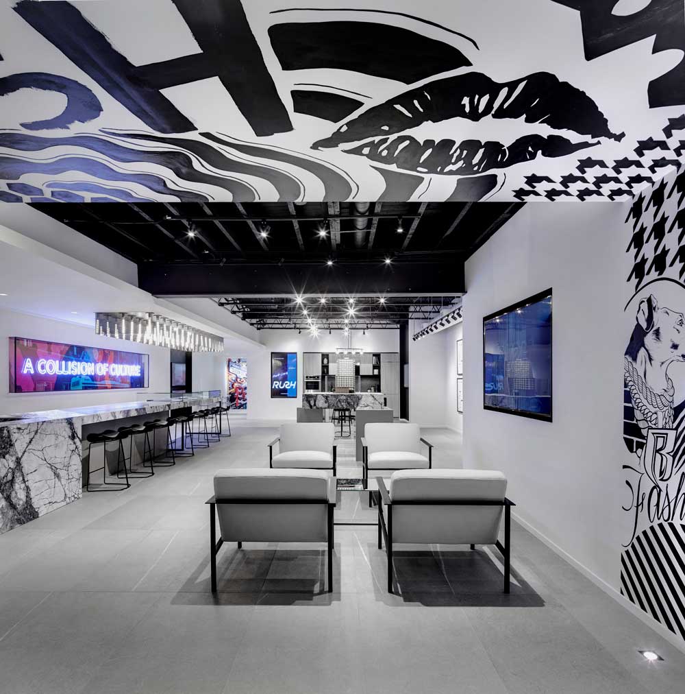 Lounge area in the very front of the space enveloped in the black and white graffiti on wall and ceiling
