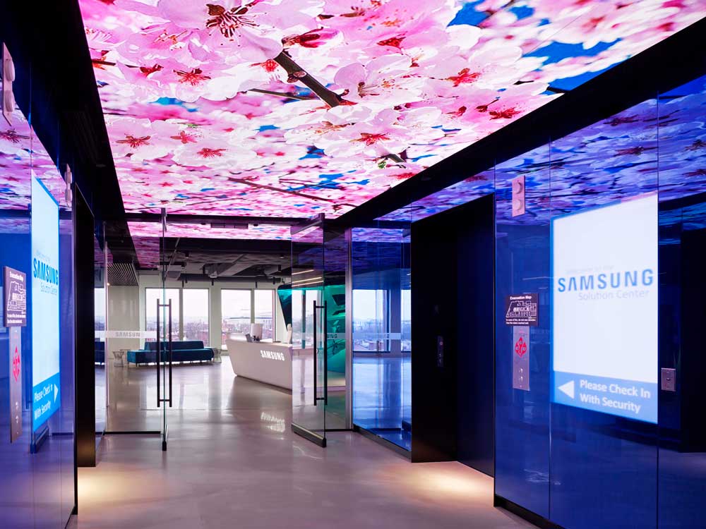 Elevator lobby with LED screens on ceiling projecting colorful images all around