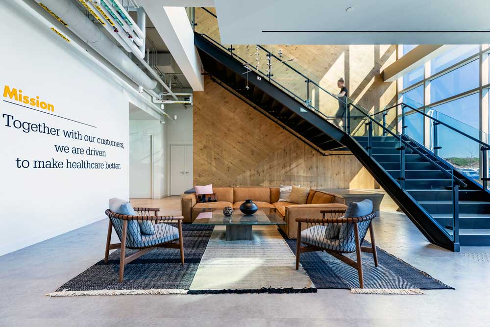 View of the waiting area at the reception located at the foot of the stairs with the light fixture installation right above it
