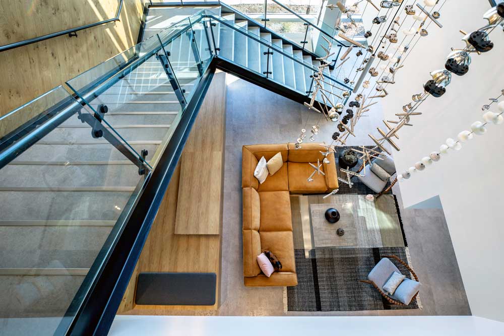 View of the lobby and reception area and the light fixture installation from the second floor looking down the stairs