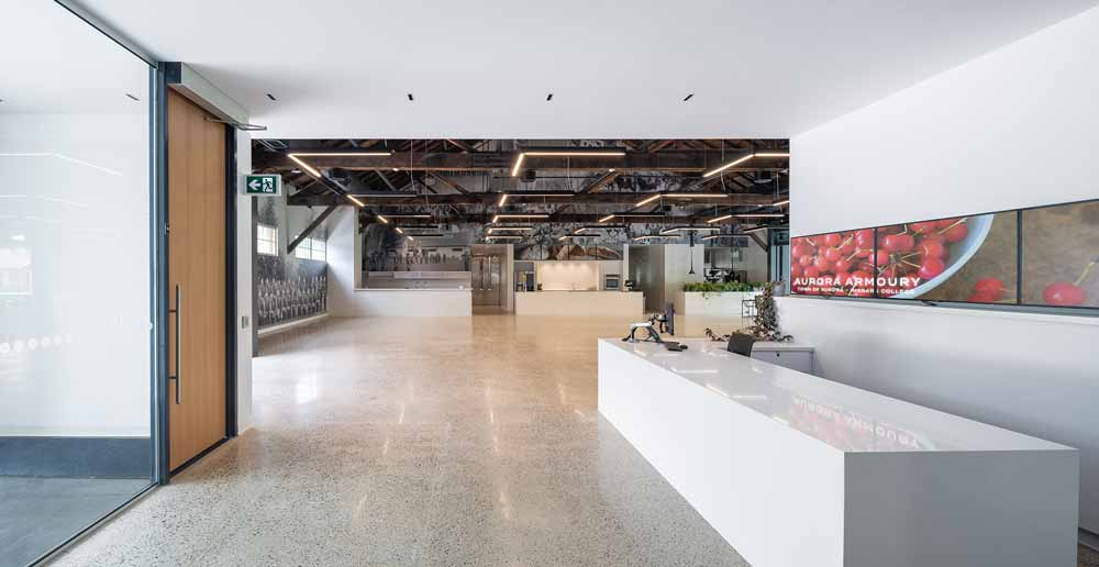 Reception area leading to an Open concept flexible space to accommodate different types of events. Archival photos arranged into large collages are throughout on walls