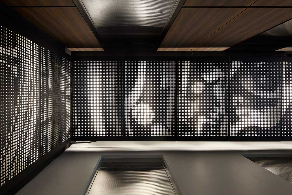 clock inspired graphic laser cut into steel panels with Diffused lighting that was carefully detailed to provide illumination through the perforations runs through the entire space