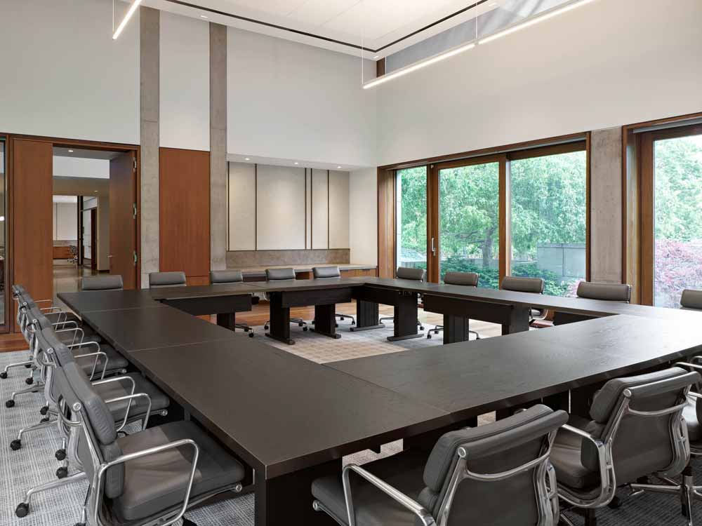 Another view of the boardroom space showing the wood detailing in door and window framing and furniture, some concrete wall elements which were preserved