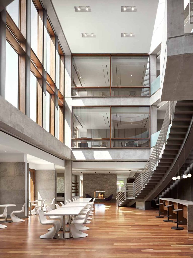 Atrium in the central area of the building with expansive common area on the ground floor and a stunning staircase leading to upper levels where the offices are