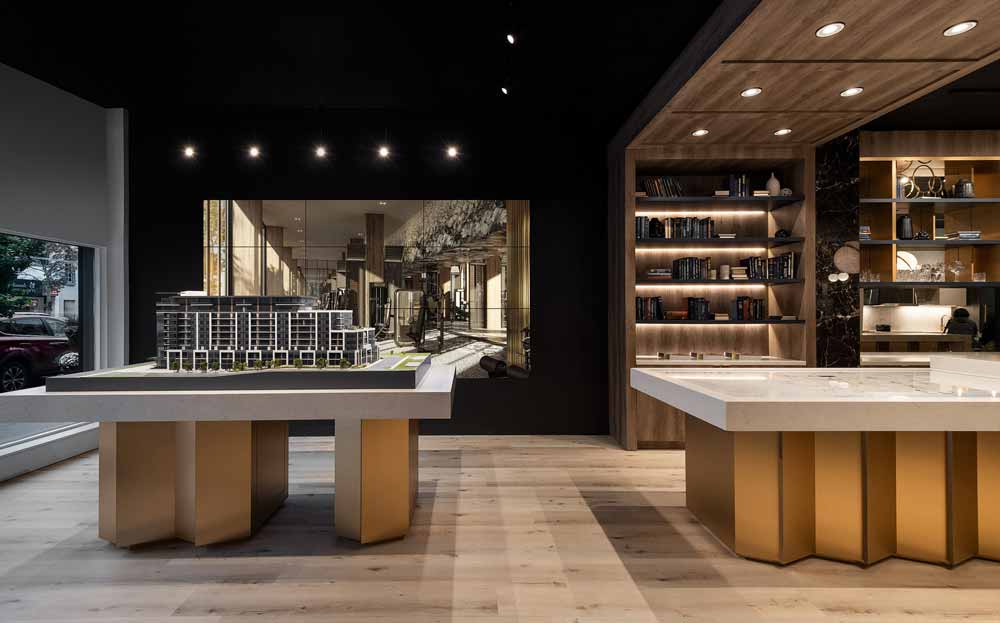 The 3D model is placed at the entrance to the stylish and elegant presentation centre, leading the visitor toward the lounge area where black, gold and wooden finishes dominate for a luxurious effect