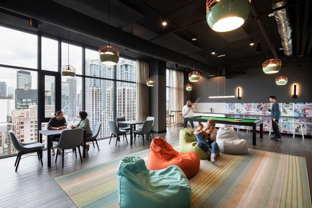 Fun games room on the top floor in a colourful hip coloiurscheme with fun graphic comic book details on the wall, pool table and areas for socializing.