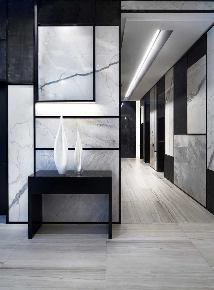 Elevator lobby walls are covered n marble and black panels to add interest
