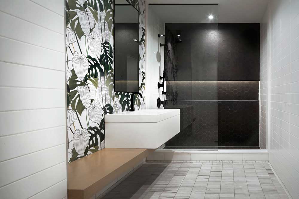 Black and white contrasting tile in the changeroom with green leaf accent wall at the vanity