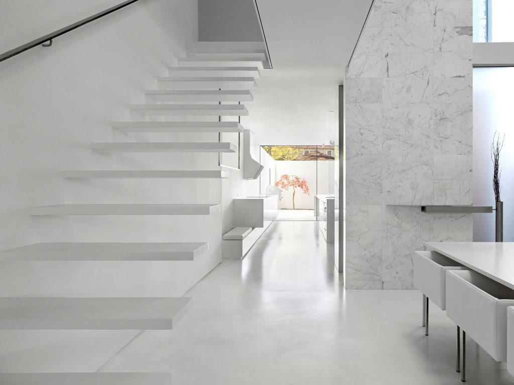A view from the dining room toward the kitchen and a view of the courtyard with one Japanese Maple in the background