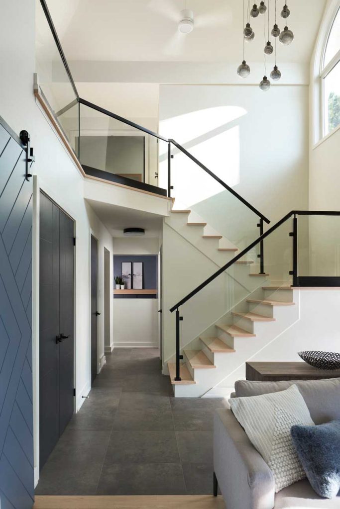 Modern staircase with a cascading chandelier showcasing the high ceilings above