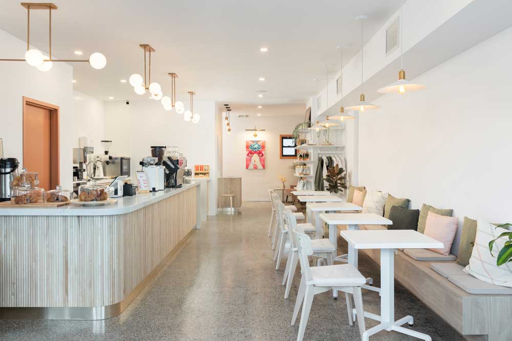 The rounded counter with wooden slat detail in the base is on the left as one walks in and the seating with tables is on the right
