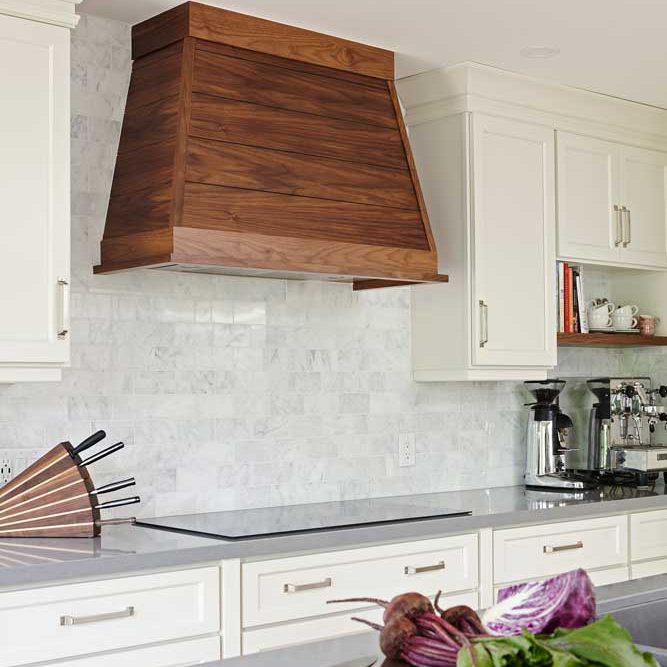 White kitchen with a wooden hood above the range