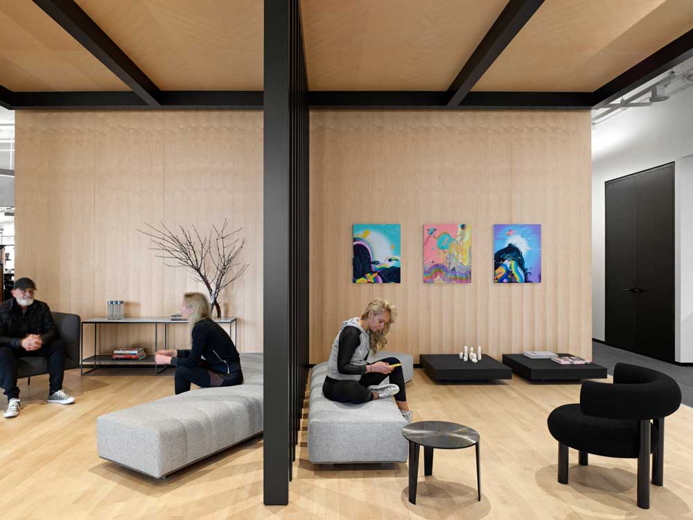 lobby features an intimate lounge with maple wood in comination with black for a modern feel and colourful commissioned artwork