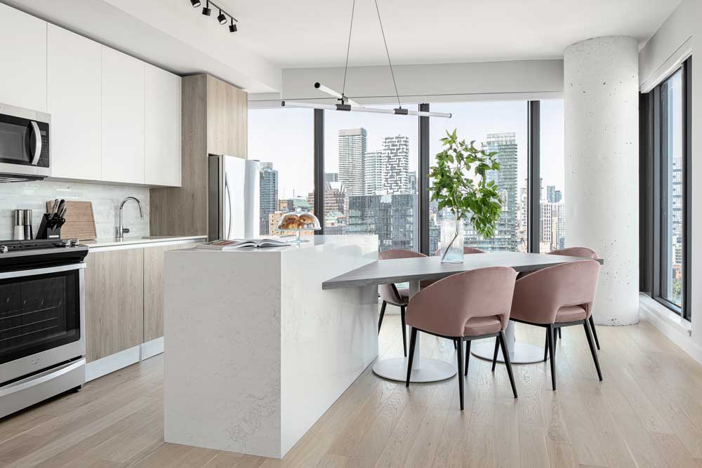 Beautiful two tone kitchen and dining area with the stunning views of Toronto in the background
