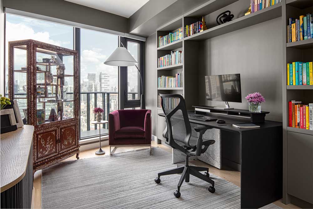 Accent lounge chair in burgundy in a monochromatic office space, with an antique Chinese cabinet as contrast to modern decor