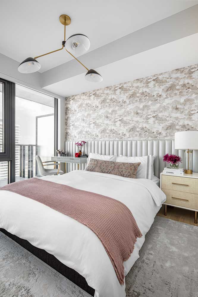 Soft coloured bedroom, featuring beautiful wallpaper and headboard, and sculptural lighting above the bed